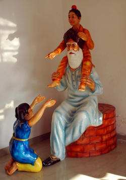 Old Man Playing With Children's Fibreglass Statue